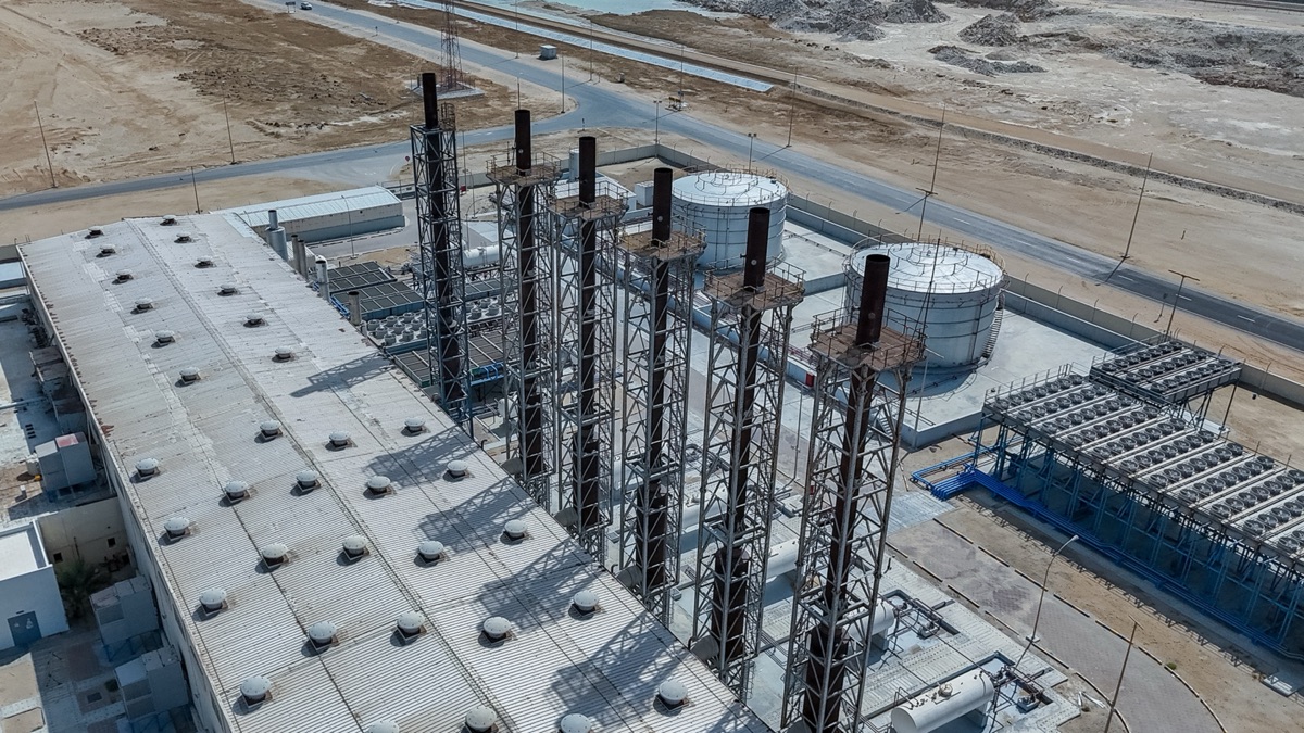 Aerial view of power station exhaust stacks beside storage tanks