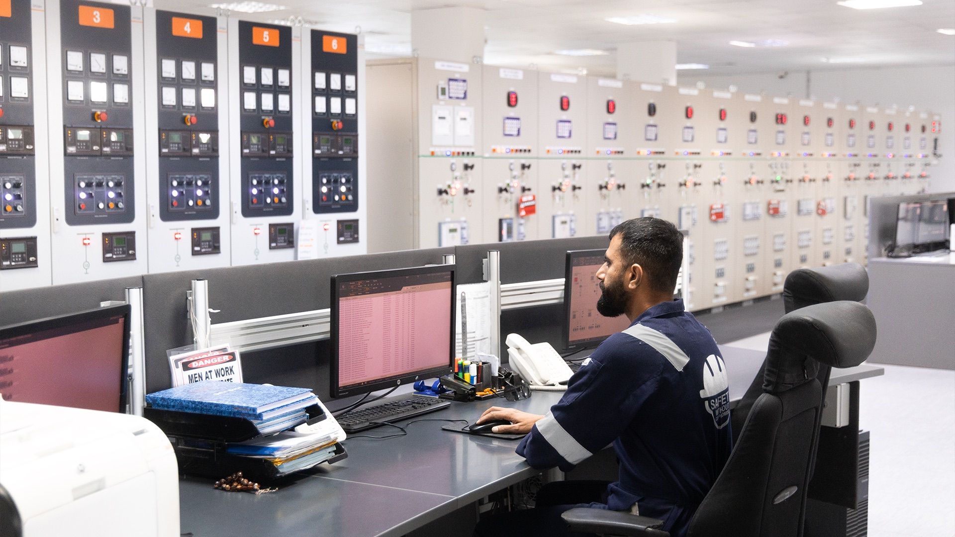 Operator monitoring screens in a power plant control room